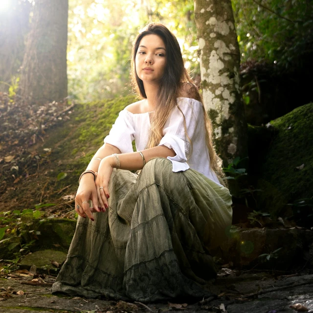 a woman sitting on a rock in the woods, an album cover, inspired by Zhang Yin, sumatraism, cottage hippie naturalist, gentle lighting, beautiful himalayan woman, promo image