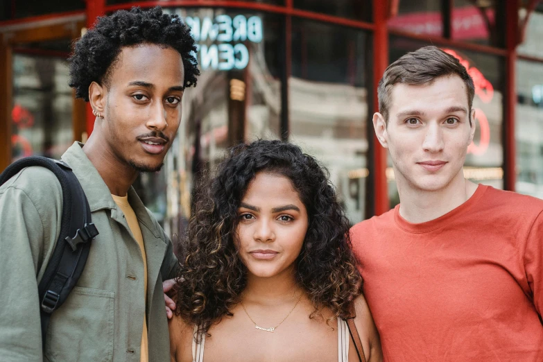 three people standing next to each other in front of a building, pexels contest winner, fair olive skin, mixed race, joel fletcher, handsome girl