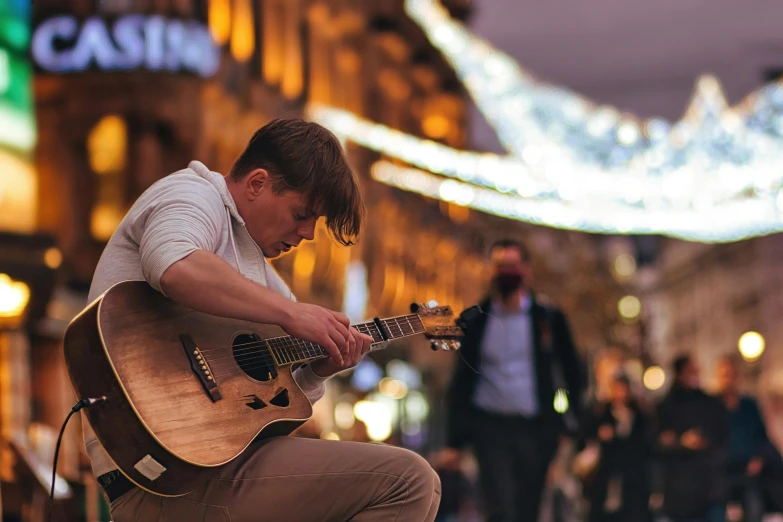 a man sitting on a bench playing a guitar, an album cover, by Nick Fudge, pexels contest winner, in the middle of the city, profile image, holiday season, thumbnail