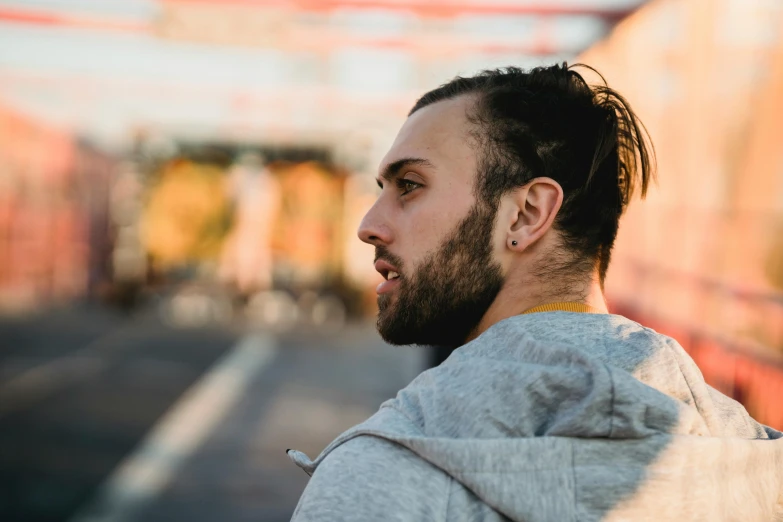 a man with a beard standing on a bridge, trending on pexels, hyperrealism, sideburns, avatar image, gauged ears, androgynous male