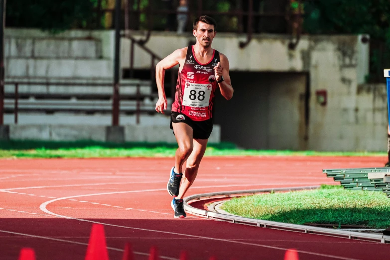 a man running in a race on a track, by Matt Stewart, pexels contest winner, wearing red shorts, 🚿🗝📝, profile image, cover shot