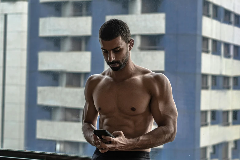 a shirtless man looking at his cell phone, pexels contest winner, middle eastern skin, muscular characters, mesomorph, pixelated