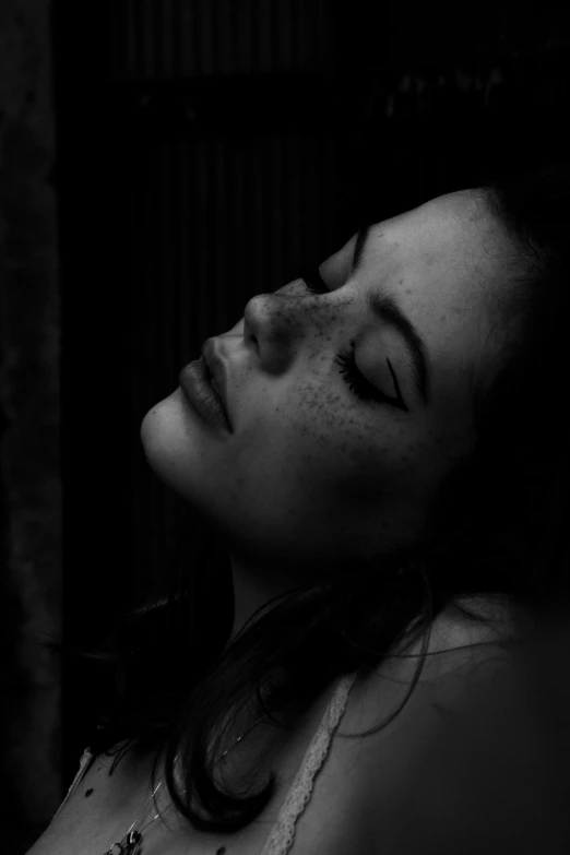 a black and white photo of a woman with her eyes closed, a black and white photo, trending on pexels, realism, face with scars, (night), beautiful lonely girl, unconscious