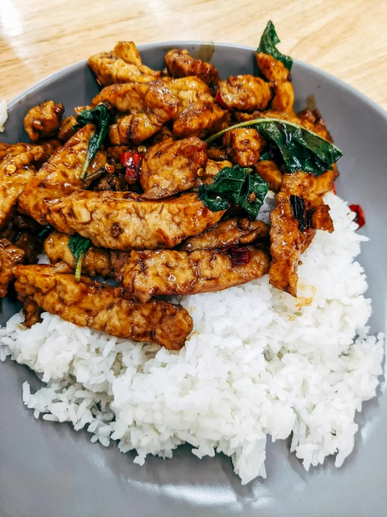 a close up of a plate of food with rice, very large basil leaves, 6 pack, rooster, 3 pm