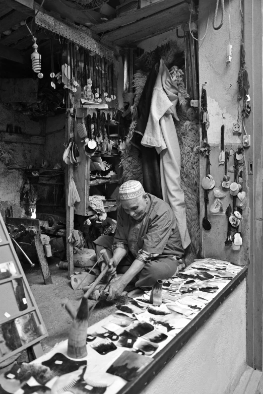 a black and white photo of a man working in a shop, a black and white photo, by Carlo Carrà, oriental scene, brush work, ( ( photograph ) ), an unknown ethnographic object