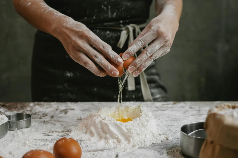 a woman sprinkles eggs in flour on a table, trending on pexels, intricate pasta waves, basil gogos, thumbnail, background image