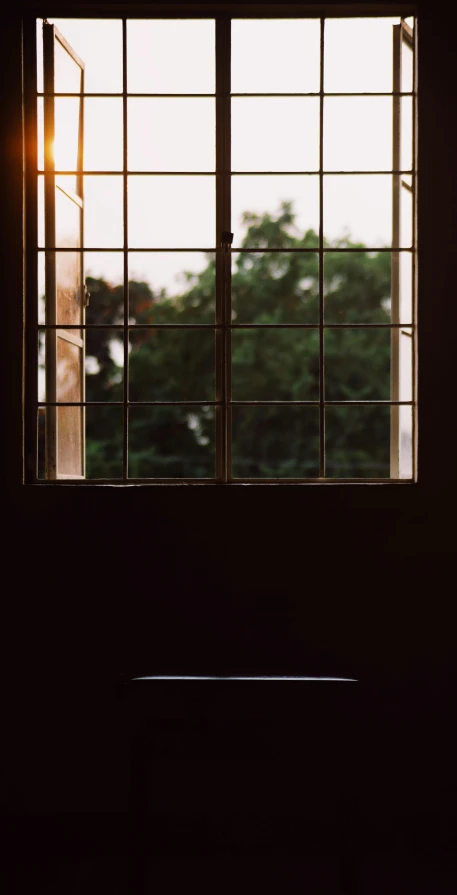 a silhouette of a person standing in front of a window, an album cover, by Elsa Bleda, unsplash, in a japanese apartment, late summer evening, church window, high quality photo