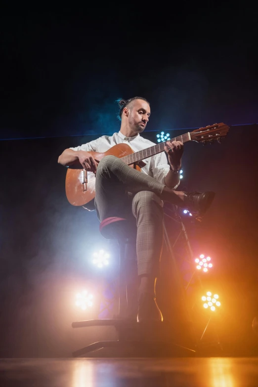 a man that is sitting down with a guitar, inspired by Cándido López, performing on stage, diego fernandez, paul barson, ana de la reguera portrait