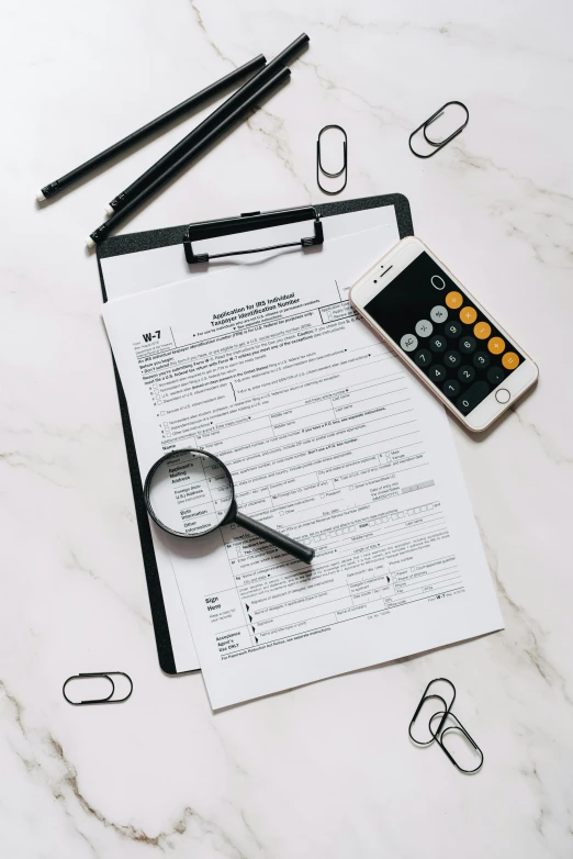 a clipboard sitting on top of a table next to a calculator, by Robbie Trevino, thumbnail, flatlay, forms, - 9