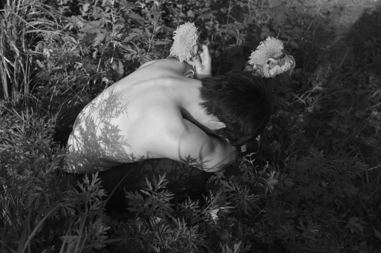 a black and white photo of a naked man in a field of flowers, a black and white photo, by Maurycy Gottlieb, conceptual art, entwined bodies, frank dillane as a satyr, hiding in grass, cai xukun