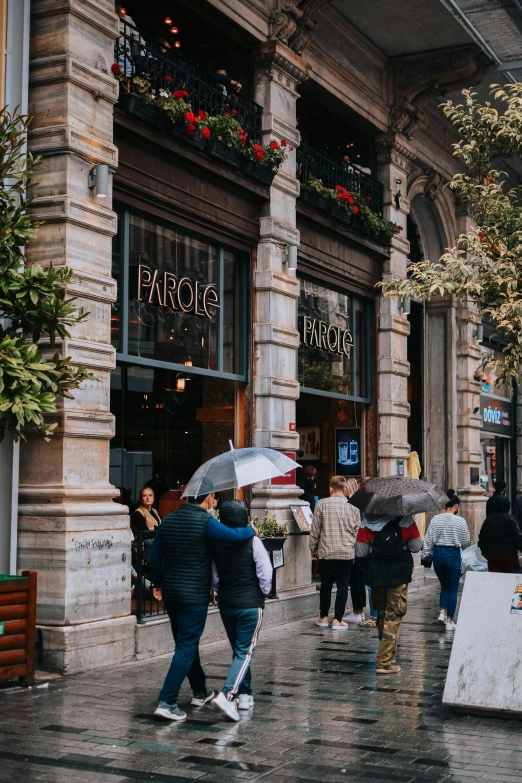 a group of people walking down a street holding umbrellas, pexels contest winner, baroque, award winning shopfront design, panoramic, fallout style istanbul, thumbnail