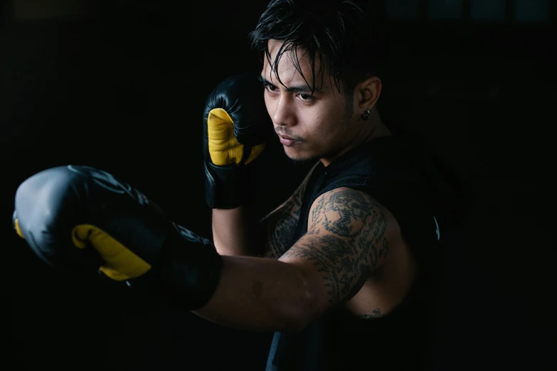 a man in a black shirt and yellow boxing gloves, a tattoo, inspired by Byron Galvez, pexels contest winner, asian male, athletic crossfit build, cosplay photo, young male