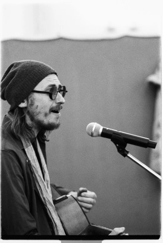 a black and white photo of a man singing into a microphone, by Greg Spalenka, jack sparrow, wearing a beanie, long chin, slightly sunny