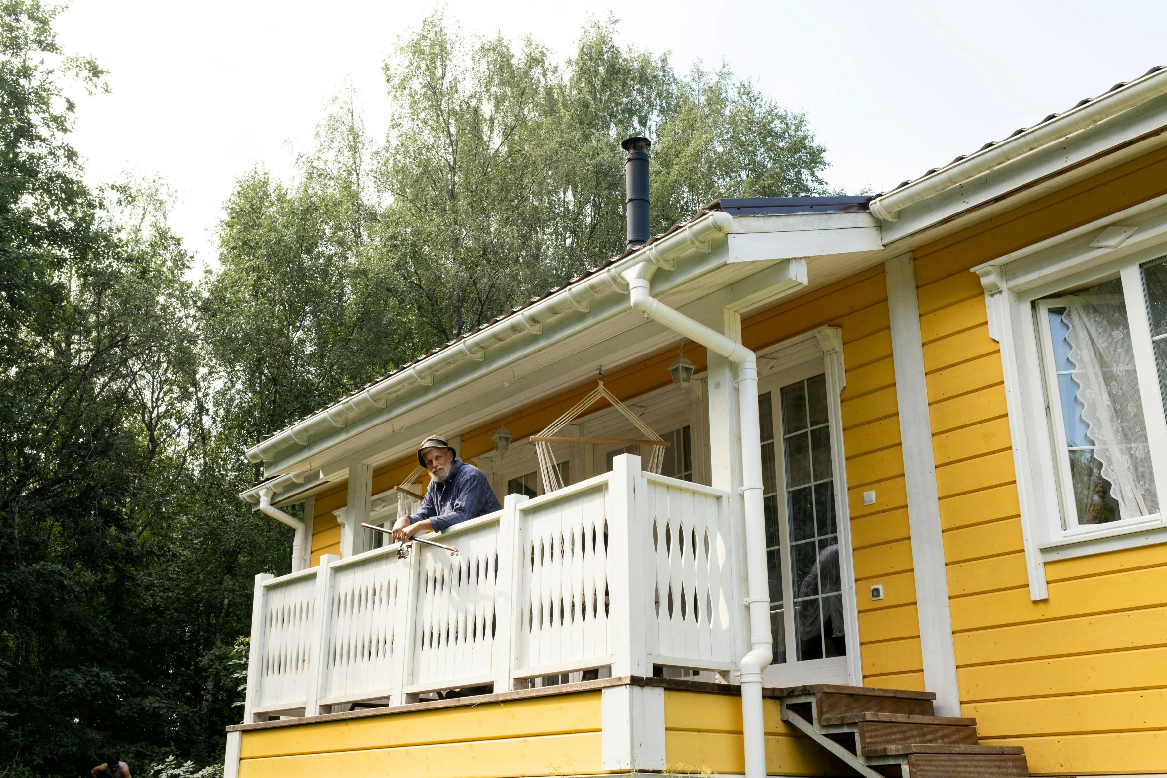 a couple of people standing on the porch of a yellow house, by Eero Järnefelt, unsplash, hurufiyya, eating, hot summer day, maintenance photo, cabin