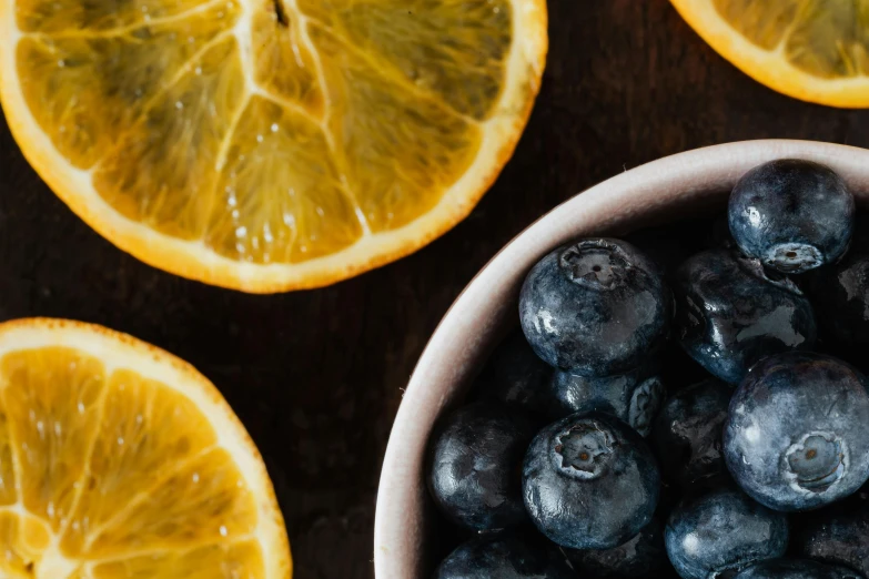 a bowl filled with blueberries next to sliced oranges, trending on pexels, 🦩🪐🐞👩🏻🦳, avatar image, background image, skin