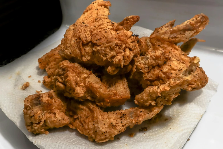 a pile of fried chicken sitting on top of a piece of paper, by Carey Morris, pexels, renaissance, bottom body close up, cooking it up, wings growing out of arms, low quality photo