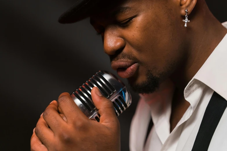 a close up of a person holding a microphone, inspired by Michael Ray Charles, pexels contest winner, harlem renaissance, beautiful man, an artistic pose, high quality upload, multiple stories