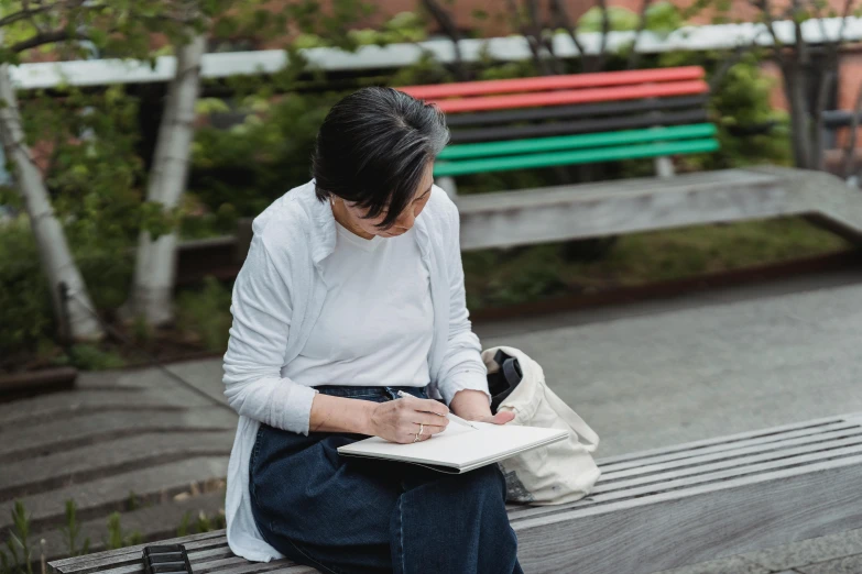 a woman sitting on a bench writing on a piece of paper, a drawing, inspired by Katsukawa Shunsen, pexels contest winner, academic art, parks and public space, portrait image, terada katsuya, drawing pictures on a notebook