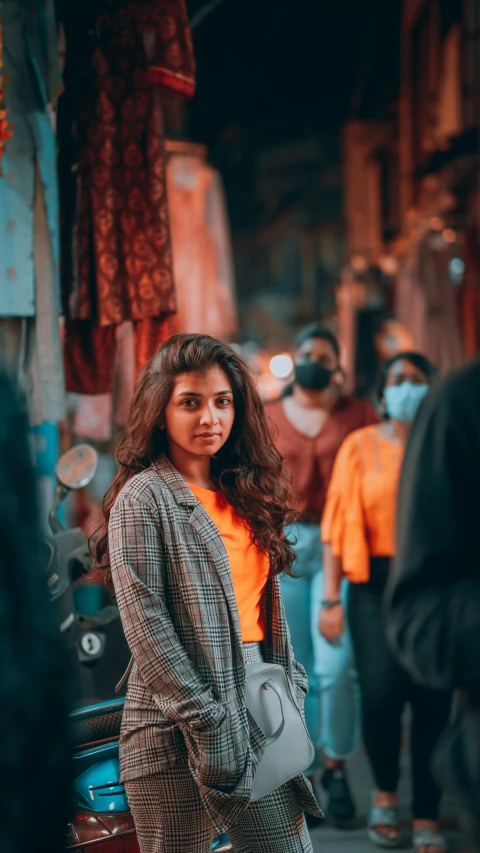 a woman standing in the middle of a crowded street, by Max Dauthendey, pexels contest winner, girl next door innocent look, orange and teal color, india, looking confident