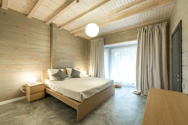 a bed sitting in a bedroom next to a window, light and space, located in hajibektash complex, pine, units, slavic