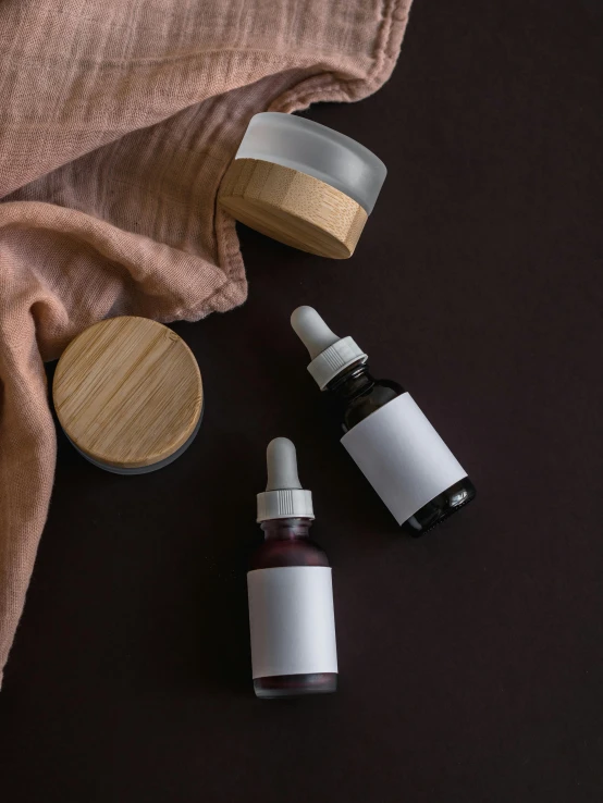 a couple of bottles sitting on top of a table, photoshoot for skincare brand, wooden bowl, thumbnail, gray canvas