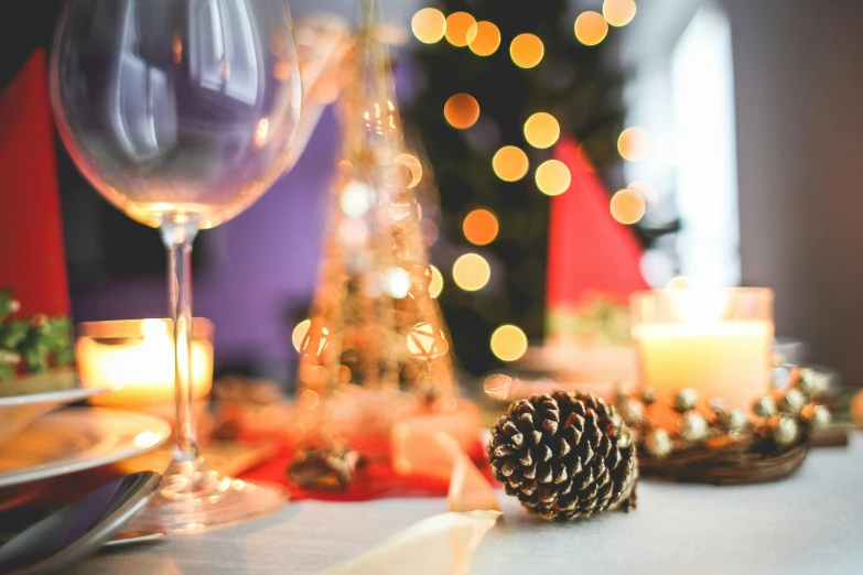 a glass of wine sitting on top of a table, by Carey Morris, pexels, decorated ornaments, pinecone, party lights, thumbnail