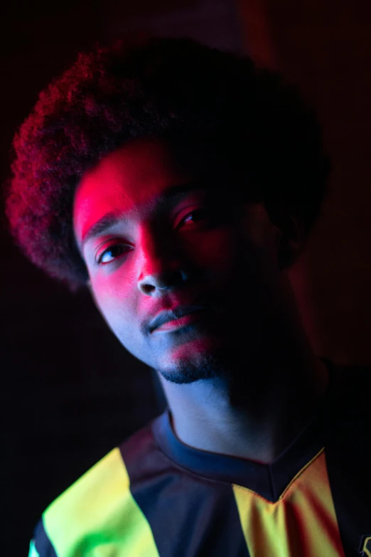 a man standing in front of a red light, an album cover, inspired by Willian Murai, pexels contest winner, glowing yellow eyes, imaan hammam, nightlife, headshot profile picture