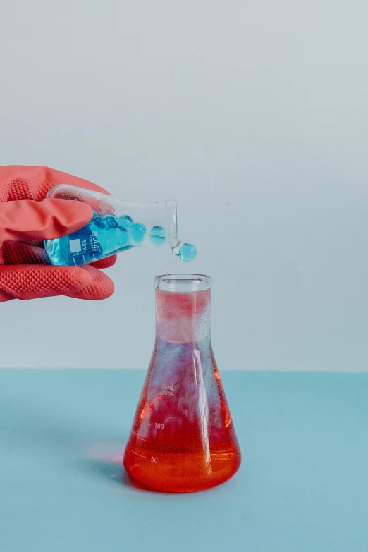 a person in red gloves is pouring liquid into a flask, pexels, process art, pink and blue colour, scientific paper, 🦑 design, silicone skin