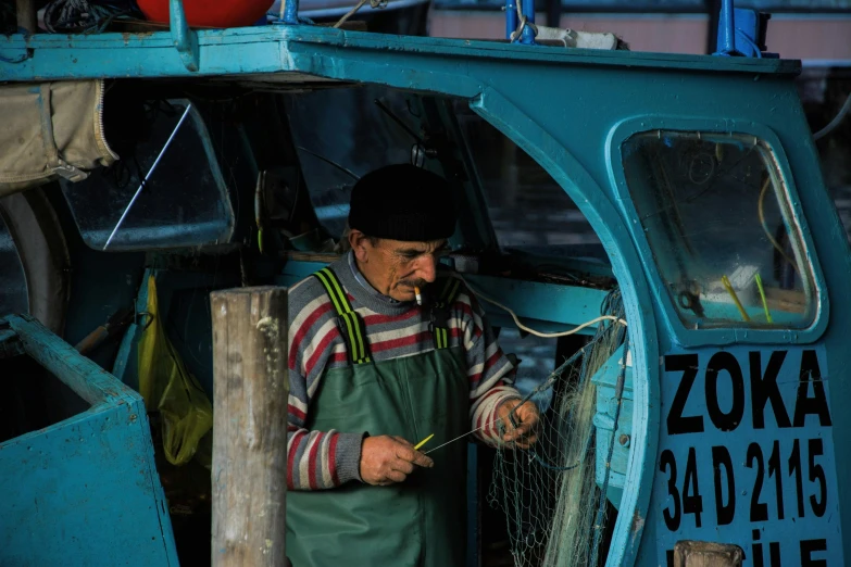 a man that is standing in front of a boat, by Attila Meszlenyi, pexels contest winner, repairing the other one, fish hooks, avatar image, spanish
