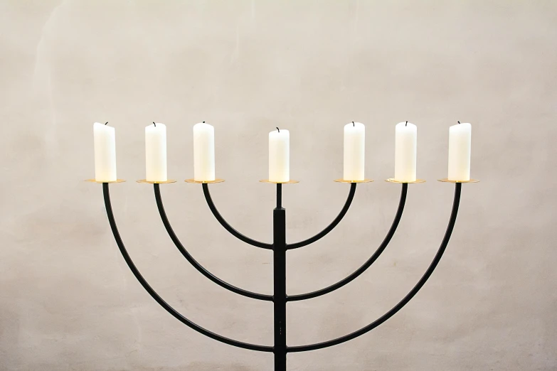 a menorah with five candles sitting on top of it, by Nina Hamnett, trending on unsplash, minimalism, made of wrought iron, 155 cm tall, brancusi, group of seven