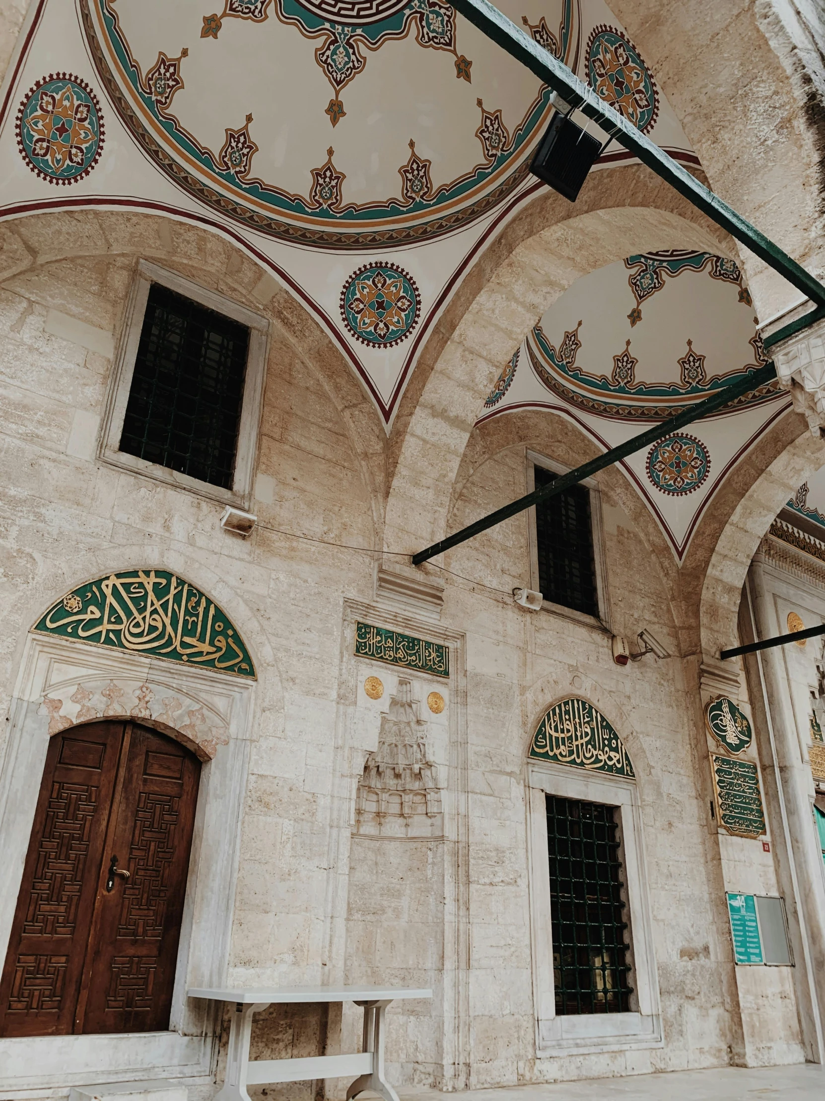 a large building with a clock on top of it, inspired by Osman Hamdi Bey, pexels contest winner, hurufiyya, tall arched stone doorways, white and teal metallic accents, overview, view