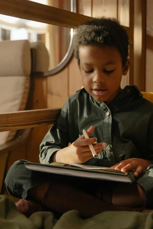 a young boy sitting on a bed reading a book, a child's drawing, by Daniel Seghers, pexels, writing on a clipboard, cinematic still, brown, thumbnail