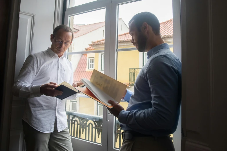 a couple of men standing in front of a window, reading, icaro carvalho, profile image