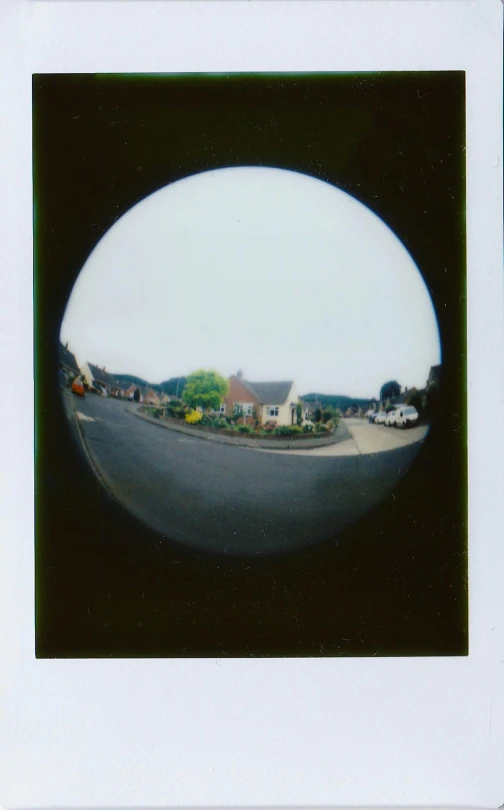 a picture of a street taken through a fish eye lens, a polaroid photo, shot from roofline, in dunwall, ((fish eye)), 7 0 mm entrance pupil diameter