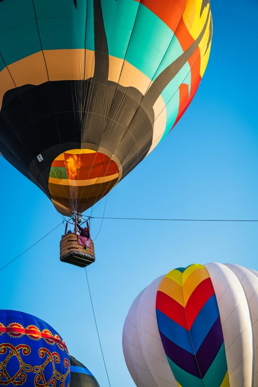 a group of hot air balloons flying through a blue sky, by Dave Melvin, happening, up-close, colors