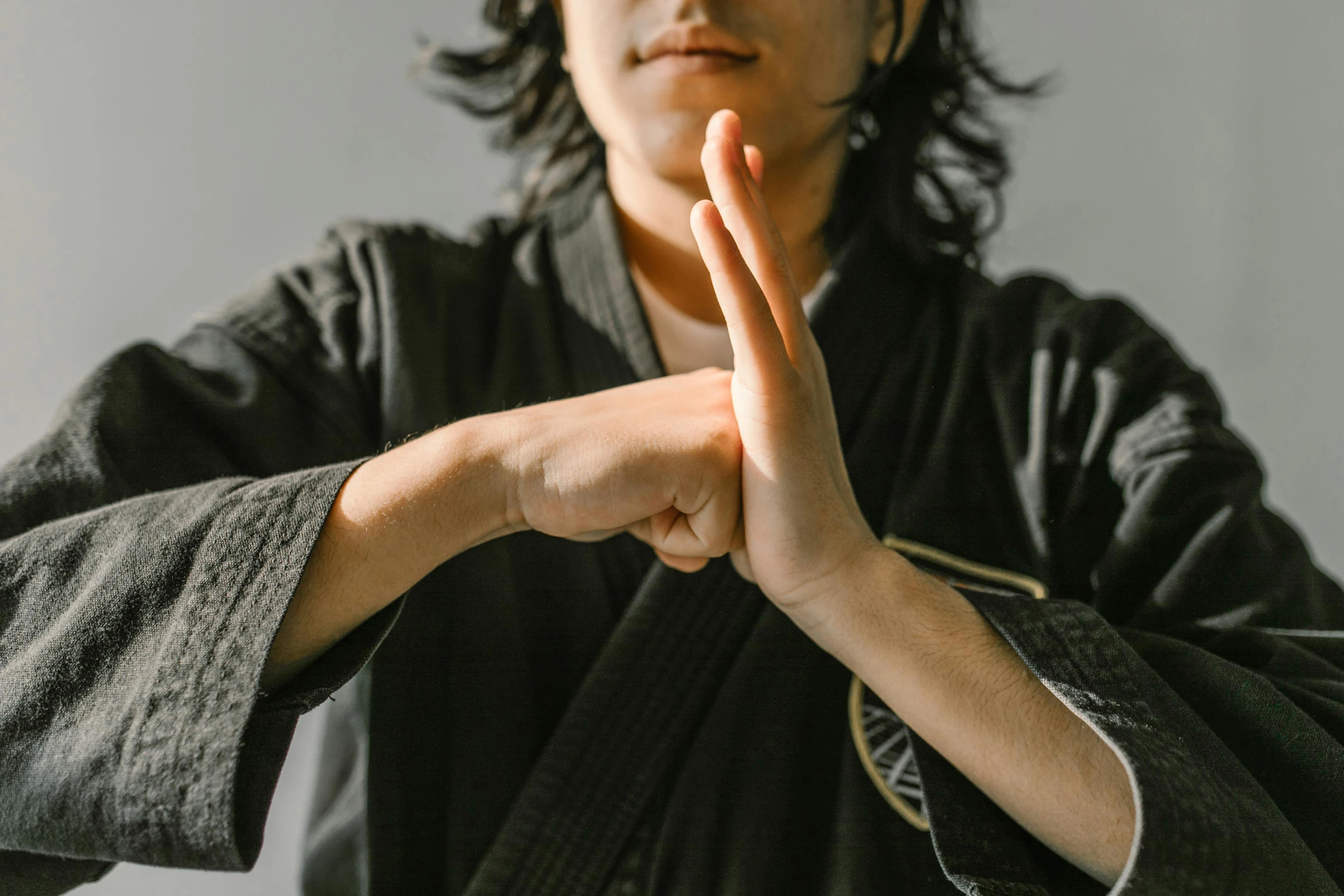 a man in a black kimono doing a hand gesture, unsplash, punching, instagram picture, uploaded, kunoichi