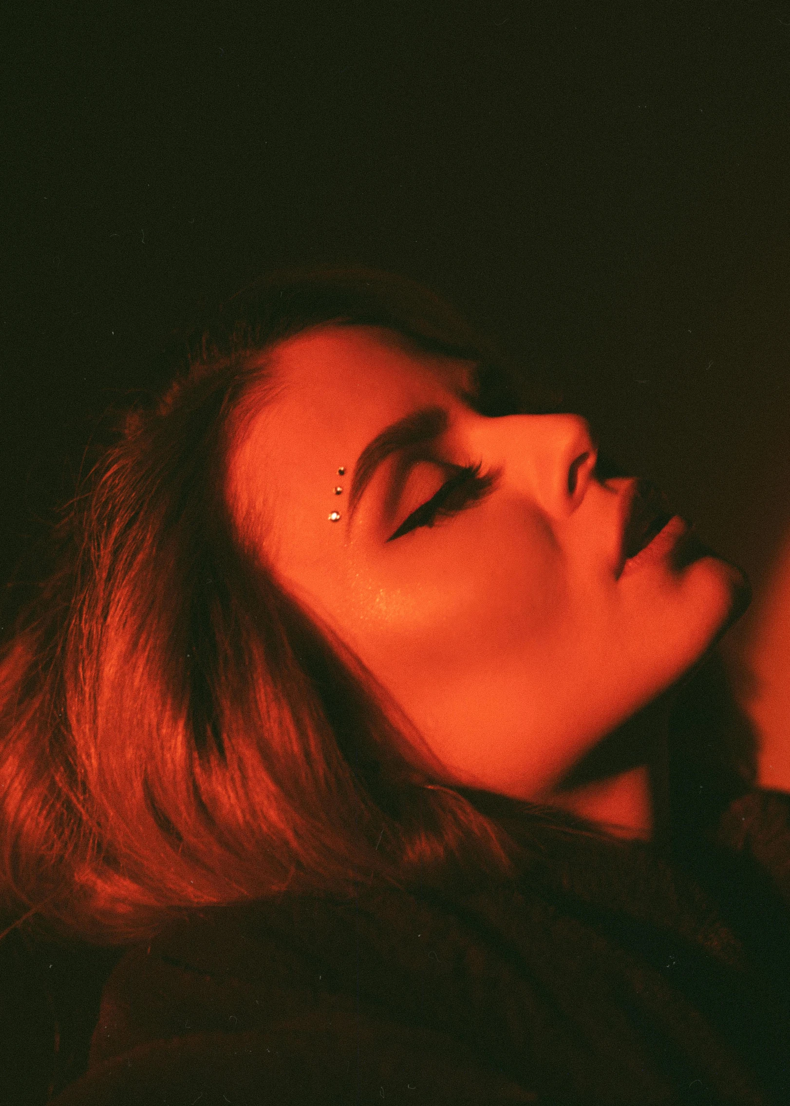 a woman holding a cell phone up to her ear, an album cover, inspired by Elsa Bleda, trending on pexels, glowing crimson head, prominent jawline, dasha taran, shot from above