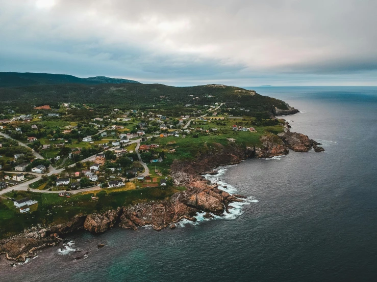 an aerial view of a small town on the coast, pexels contest winner, happening, francois legault, hills and ocean, rocky coast, farming