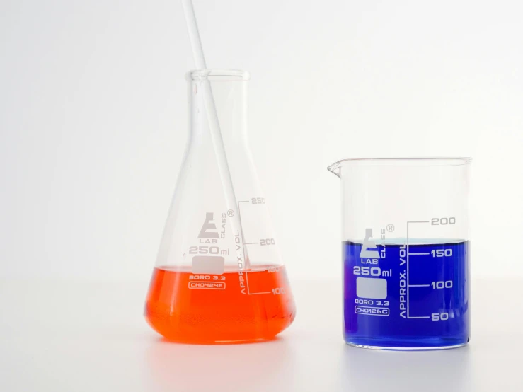 a couple of beakles sitting next to each other, unsplash, process art, scientific glassware, blue and orange color scheme, educational supplies, red liquid