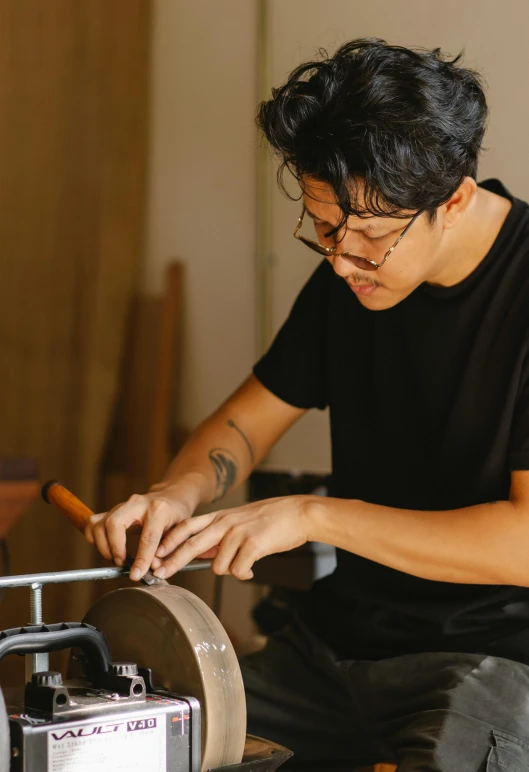 a man is working on a piece of wood, a portrait, inspired by Joong Keun Lee, trending on unsplash, drummer, ouchh and and innate studio, female blacksmith, avatar image