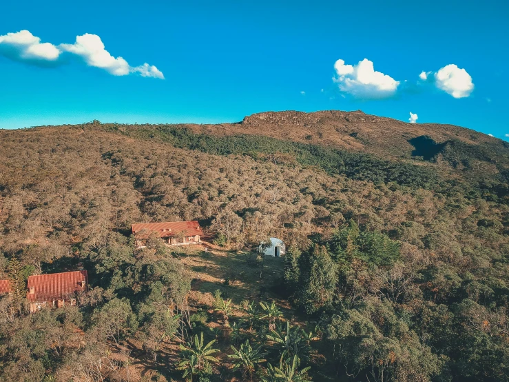 a house sitting on top of a lush green hillside, a portrait, pexels contest winner, bushveld background, campsites, top down view, 90s photo