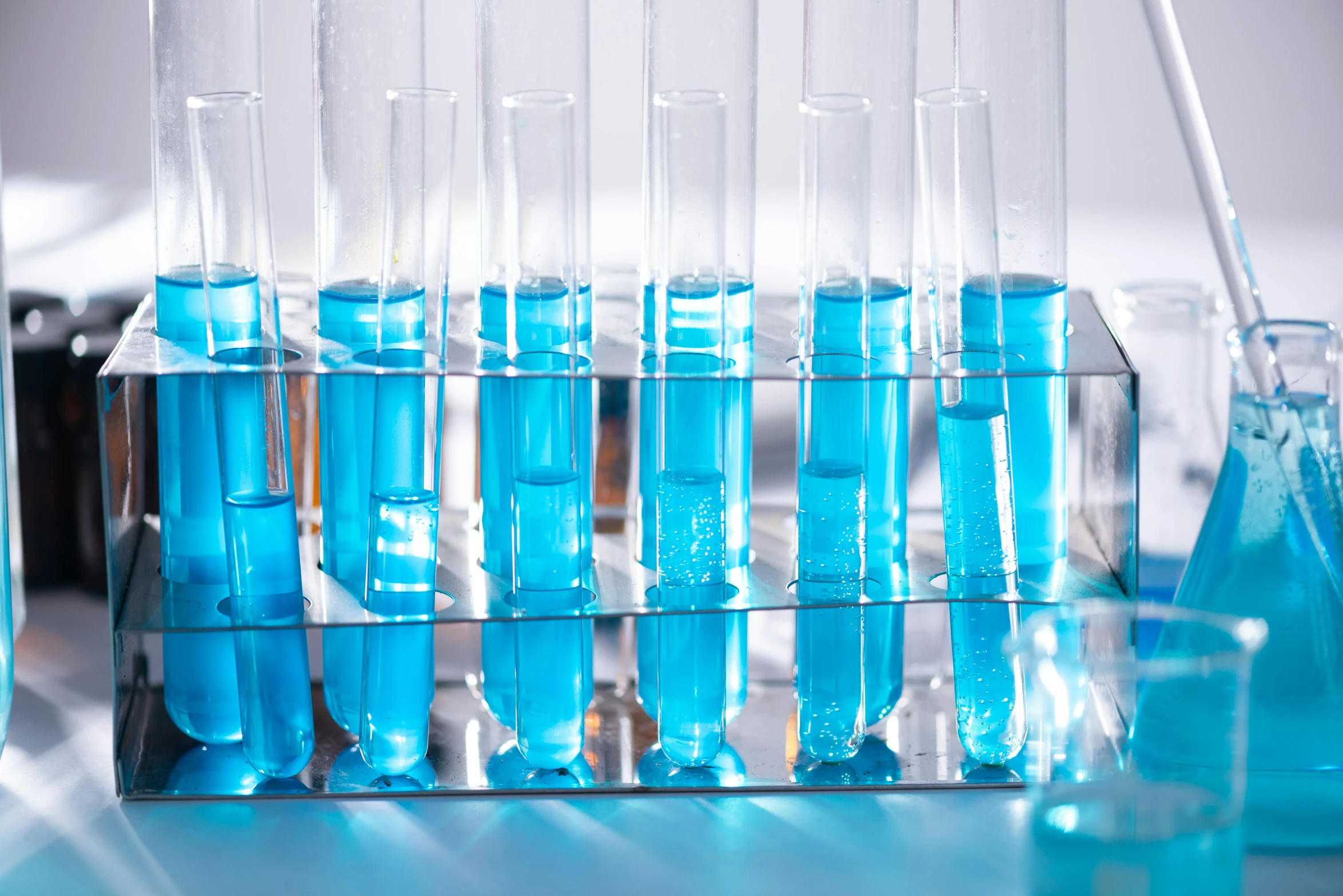 a row of test tubes filled with blue liquid, unsplash, turquoise, biroremediation plant, steroid use, vibrant scene