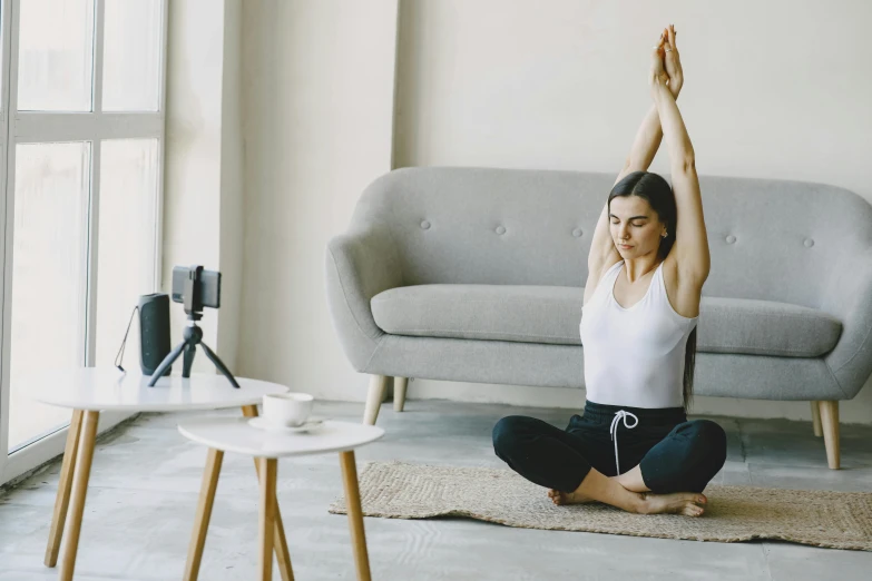 a woman doing yoga in a living room, trending on pexels, arabesque, background image, highly realistic. live cam, gorecore, sitting in a waiting room