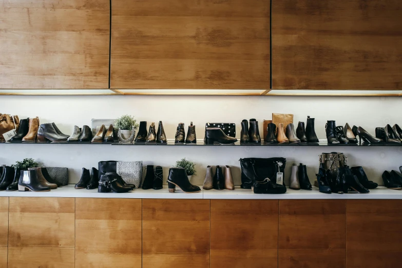 a wall filled with lots of different types of shoes, unsplash, wearing black boots, shelf, luxury fashion, bags on ground