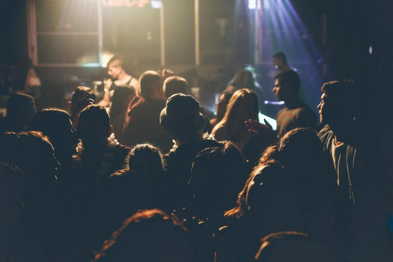 a crowd of people standing in front of a stage, pexels, inside a bar, softly - lit, thumbnail, dancefloor