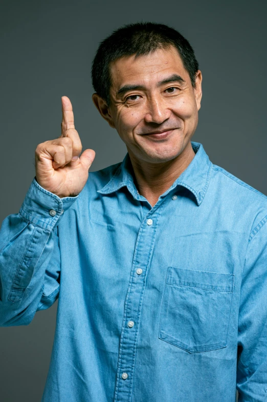 a man in a blue shirt making a peace sign, shin hanga, professional profile photo, ernie chan, promo image, aged 4 0