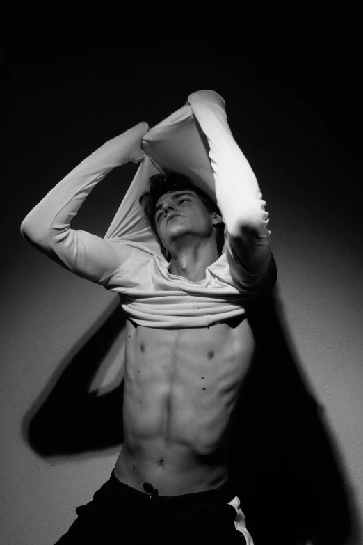 a black and white photo of a shirtless man, inspired by Roberto Ferri, declan mckenna, ripped up white garment, pose reference, contorted