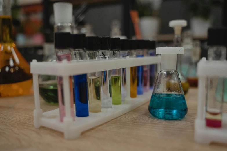 a row of test tubes filled with liquid, unsplash, perfume, sitting on a lab table, multicoloured, portrait photo