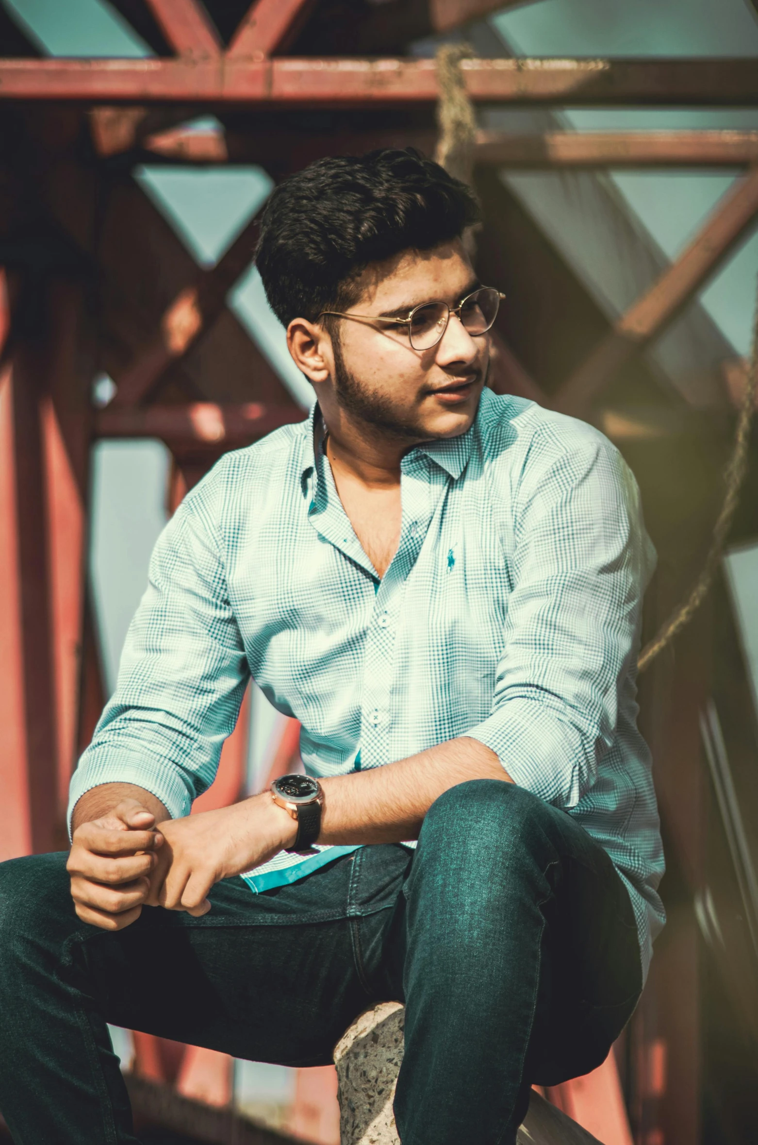 a man sitting on the edge of a bridge, by Max Dauthendey, pexels contest winner, halfbody headshot, student, on simple background, mogul khan