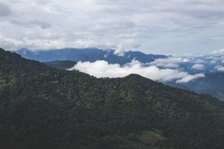 a group of people standing on top of a lush green hillside, pexels contest winner, sumatraism, clouds visible, dark forests surrounding, taken from a plane, thumbnail